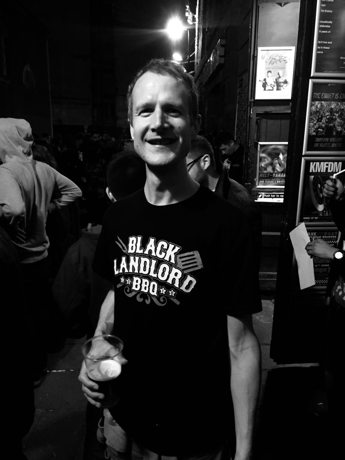 Photo of Ben Corrigan with a beer and wearing a Black Landlord T-shirt